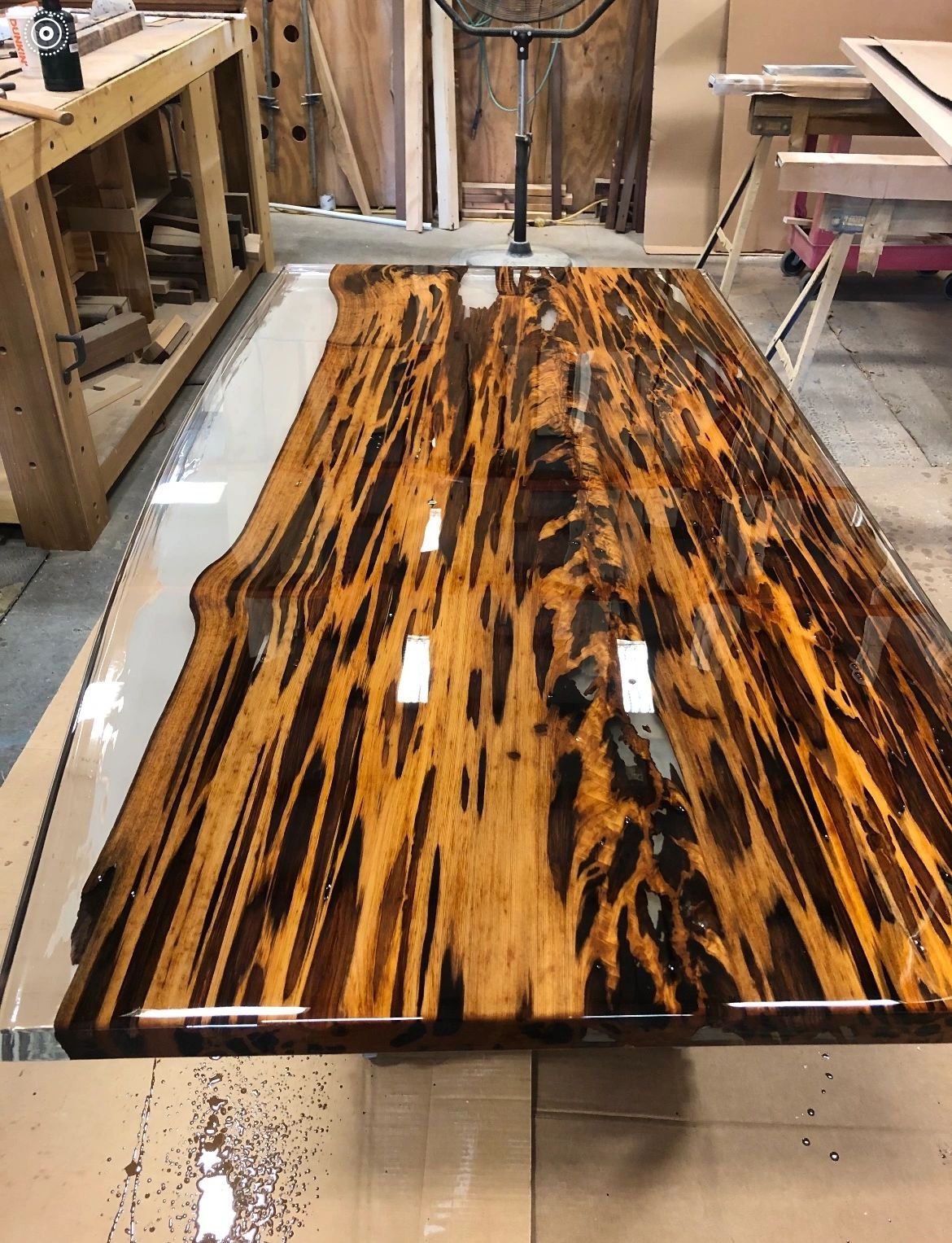 Long pecky cypress table with a high-gloss epoxy finish in the workshop