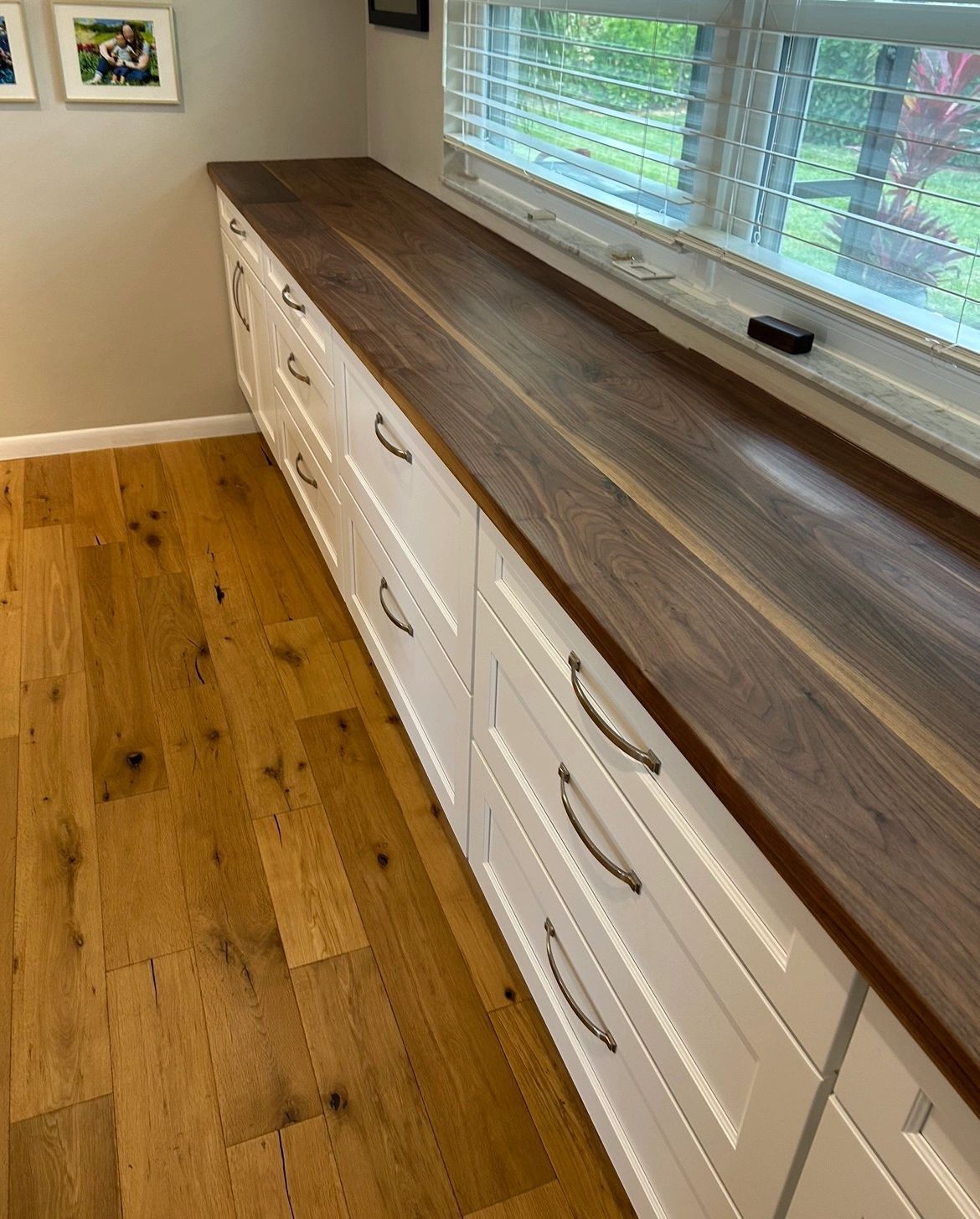 Walnut window counter. A long walnut top over white built-in drawers.